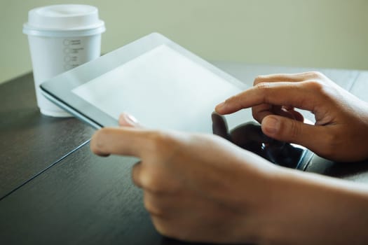 close up hand use tablet on table