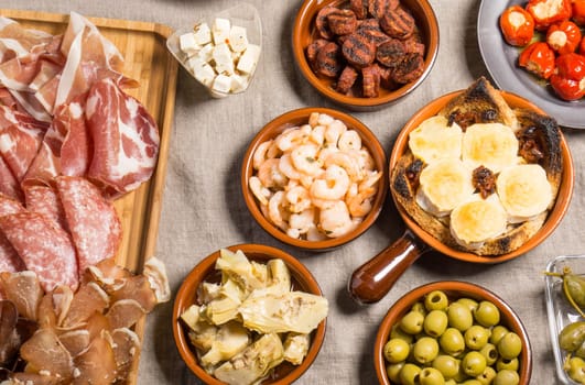 Tapas food, served in small bowls cold meat, goat cheese. A meal for sharing