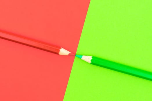 Green and Red coloured pencils and paper, abstract contrast conceptual image