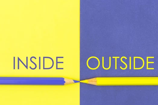 Inside versus Outside contrast concept . Yellow and Violet coloured pencils and paper.
