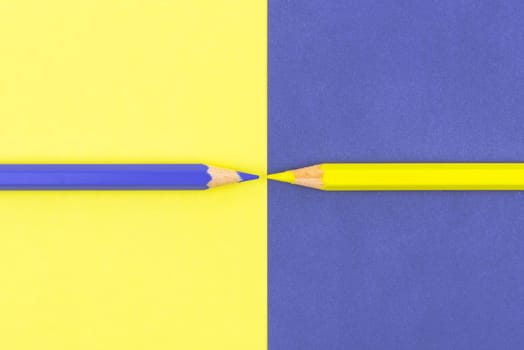 Yellow and Violet coloured pencils and paper, abstract contrast conceptual image
