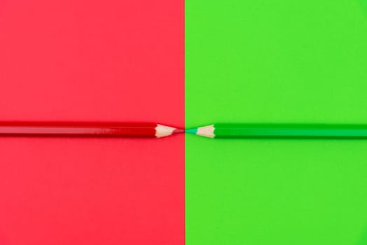Green and Red coloured pencils and paper, abstract contrast conceptual image