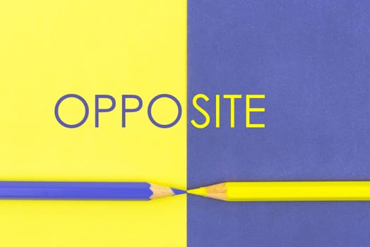 Word OPPOSITE. Yellow and Violet coloured pencils and paper, abstract contrast conceptual image