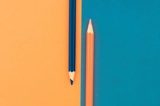 Orange and Dark Blue coloured pencils and paper, abstract contrast conceptual image