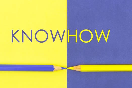 KnowHow concept with Yellow and Violet coloured pencils and paper.