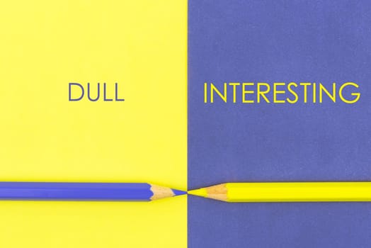 Dull versus Interesting contrast concept . Yellow and Violet coloured pencils and paper.