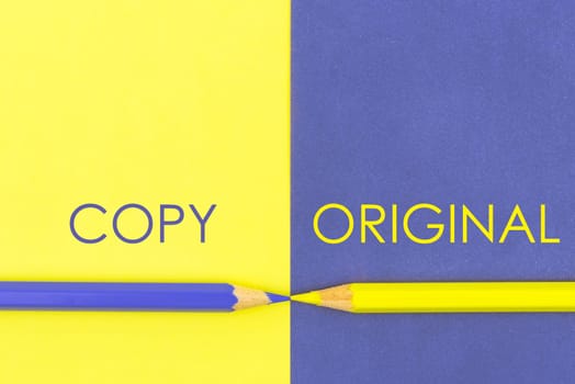 Copy versus Original contrast concept . Yellow and Violet coloured pencils and paper.