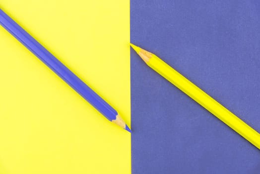 Yellow and Violet coloured pencils and paper, abstract contrast conceptual image