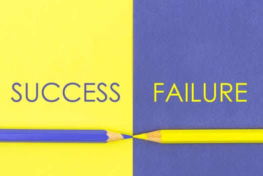 Success versus Failure contrast concept . Yellow and Violet coloured pencils and paper.