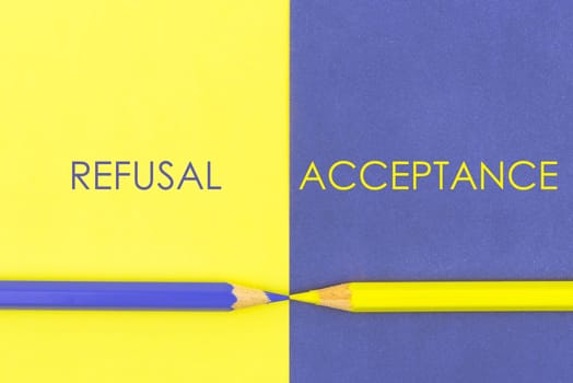 Refusal versus Acceptance contrast concept . Yellow and Violet coloured pencils and paper.