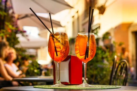 Aperol Spritz Cocktail. Alcoholic beverage based on table with ice cubes and oranges.