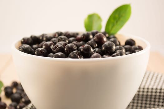 White bowl full with fresh and tasty aronia