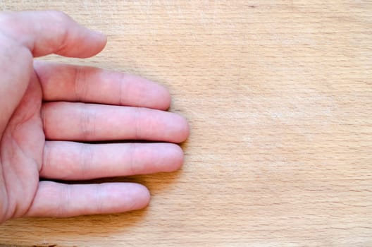 Human hand over wooden background and place for text