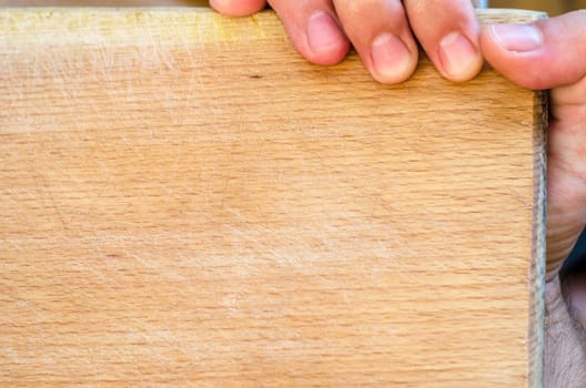 Human hand over wooden background and place for text