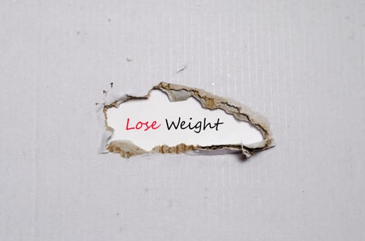 The word lose weight appearing behind torn paper