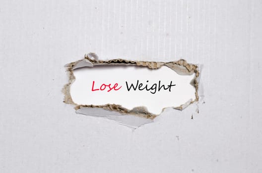 The word lose weight appearing behind torn paper