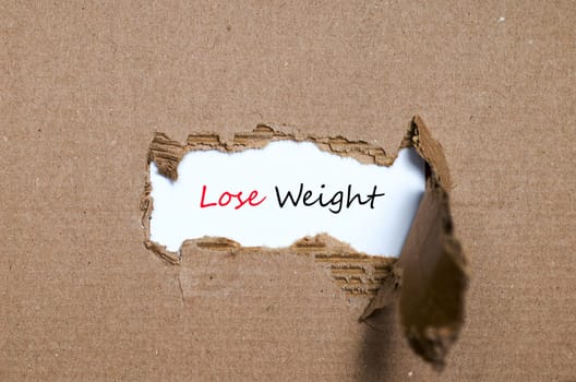 The word lose weight appearing behind torn paper