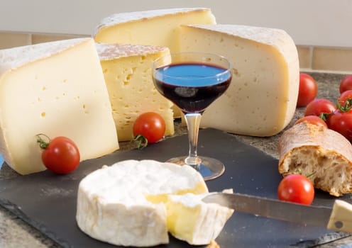 various french cheeses with a glass of red wine