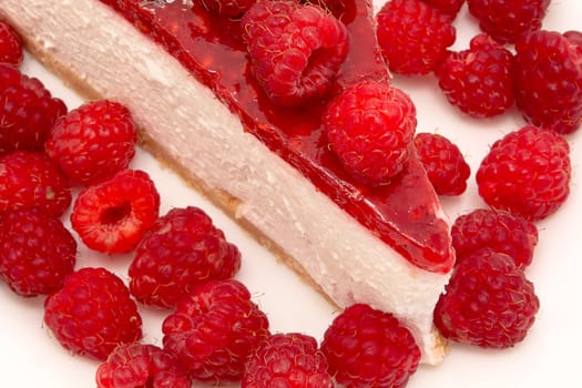 Cheesecake slice with raspberries on a white plate isolated on a white background