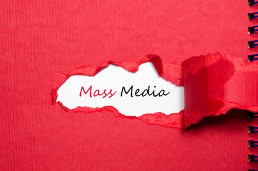 The word mass media appearing behind torn paper