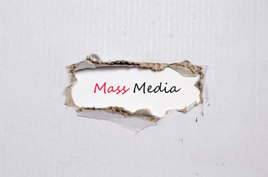 The word mass media appearing behind torn paper