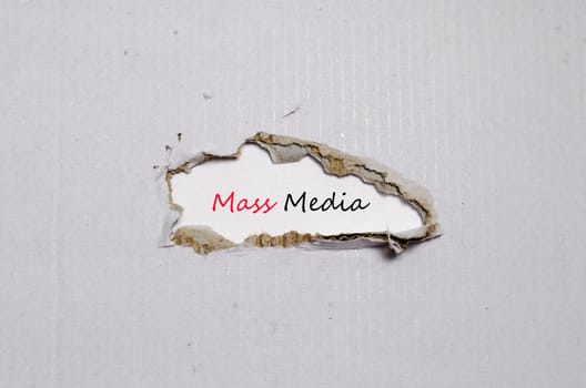 The word mass media appearing behind torn paper