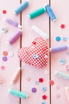 Heart-shaped pincushions with colorful yarns and buttons