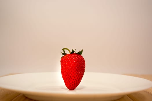 Strawberry standing up in the white ceramic plate
