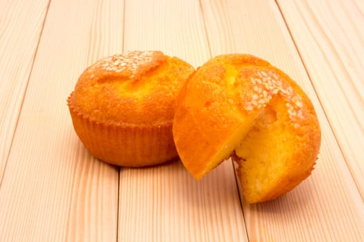 Muffins with sesame seeds on top lying on table
