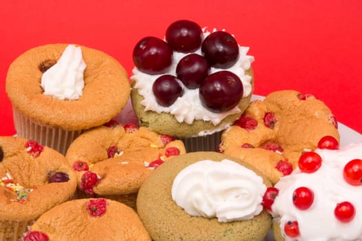 Fruit cupcakes on a plate isolated on red background