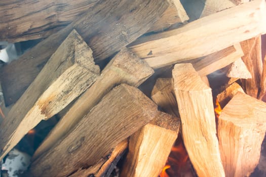 Closeup of logs smoking and burrning in preparation for nice barbecue