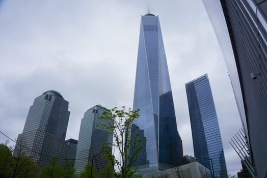 New York City, United States of America - May 01,2016: The almost finished One World Trade Center and memorial site in New York with blue sky on June 23, 2013