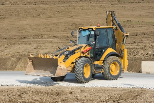 Taman, Russia - March 8, 2016: Excavator standing on a road under construction