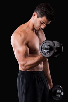 Portrait of a muscular man lifting weights against a dark background