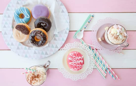 Hot chocolate with marshmallows and colorful donuts