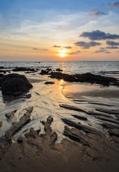 Tropical rock beach sunset with beautiful cloudscape skyline