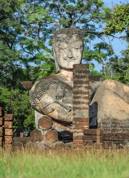 Ancient and ruins Buddha statue in Kamphaeng Phet Historical Park, Thailand. Low angle view image