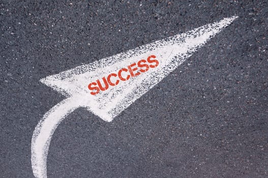 Directional white painted arrow with word SUCCESS over road surface, concept image