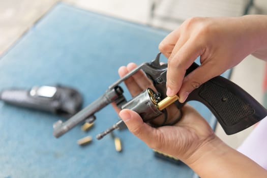 people load bullets into revolver gun befor shooting