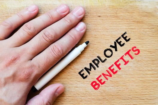 Human hand over wooden background and employee benefits text concept