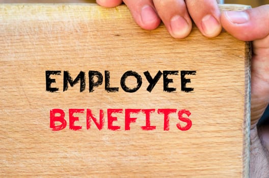 Human hand over wooden background and employee benefits text concept