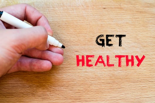 Human hand over wooden background and get healthy text concept