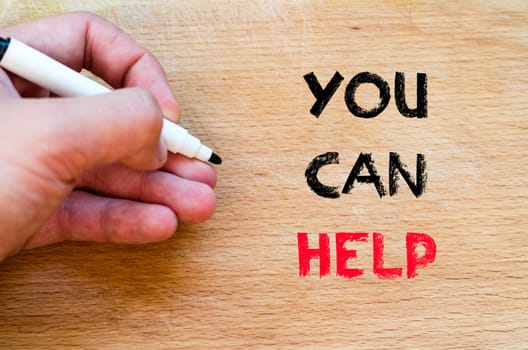Human hand over wooden background and you can help text concept