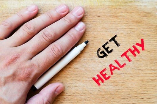 Human hand over wooden background and get healthy text concept
