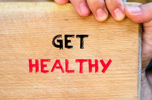 Human hand over wooden background and get healthy text concept