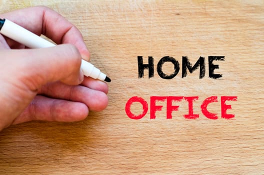 Human hand over wooden background and home office text concept