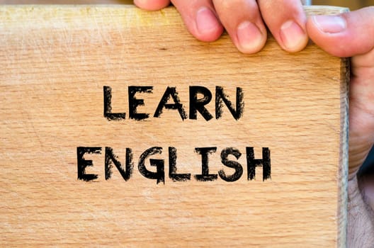 Human hand over wooden background and learn english text concept