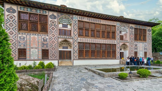 Shaki, Azerbaijan - May 15, 2024: Intricate architecture of Shaki Khan's Palace, in Shaki, Azerbaijan, surrounded by lush greenery