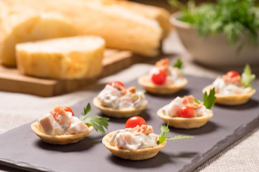 canapes, appetizer with creamy Chicken salad served on a slate plate