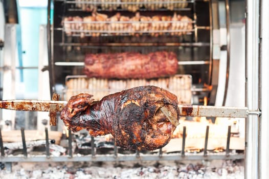 Roasted leg of pork on the barbecue skewer.